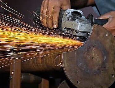 Grinding a metal part with sparks flying